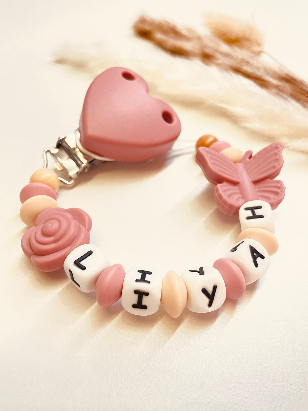 Schnullerkette Schmetterling mit Rose in altrosa, personalisiert mit Namen