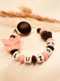 Schnullerkette Schmetterling mit Rose schwarz rosa, personalisiert mit Namen