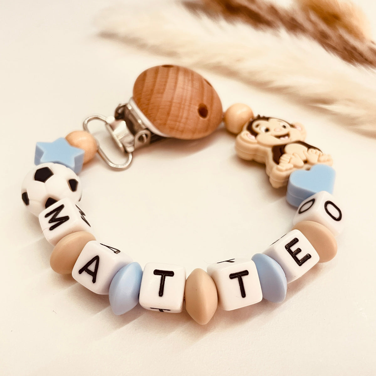 Schnullerkette Affe mit Fußball in blau-beige, personalisiert mit Namen